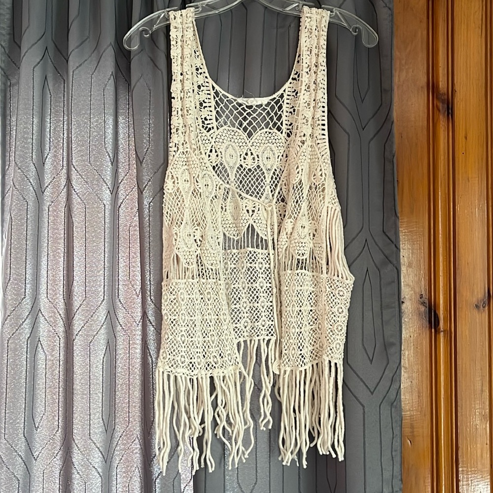 Crochet style sleeveless ivory cardigan.